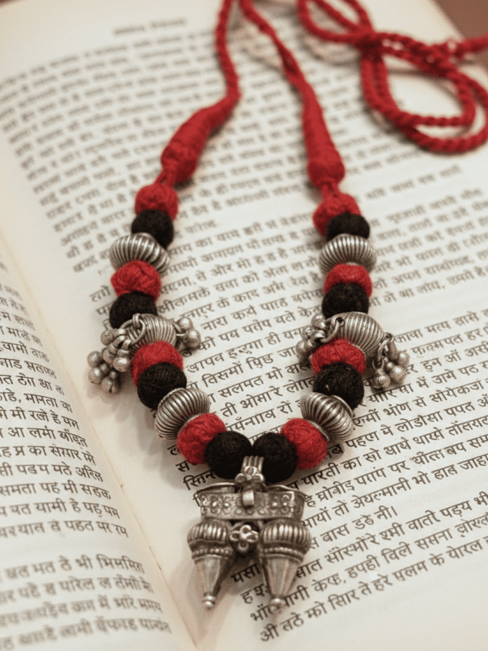 Necklace with red and black beads on an open book