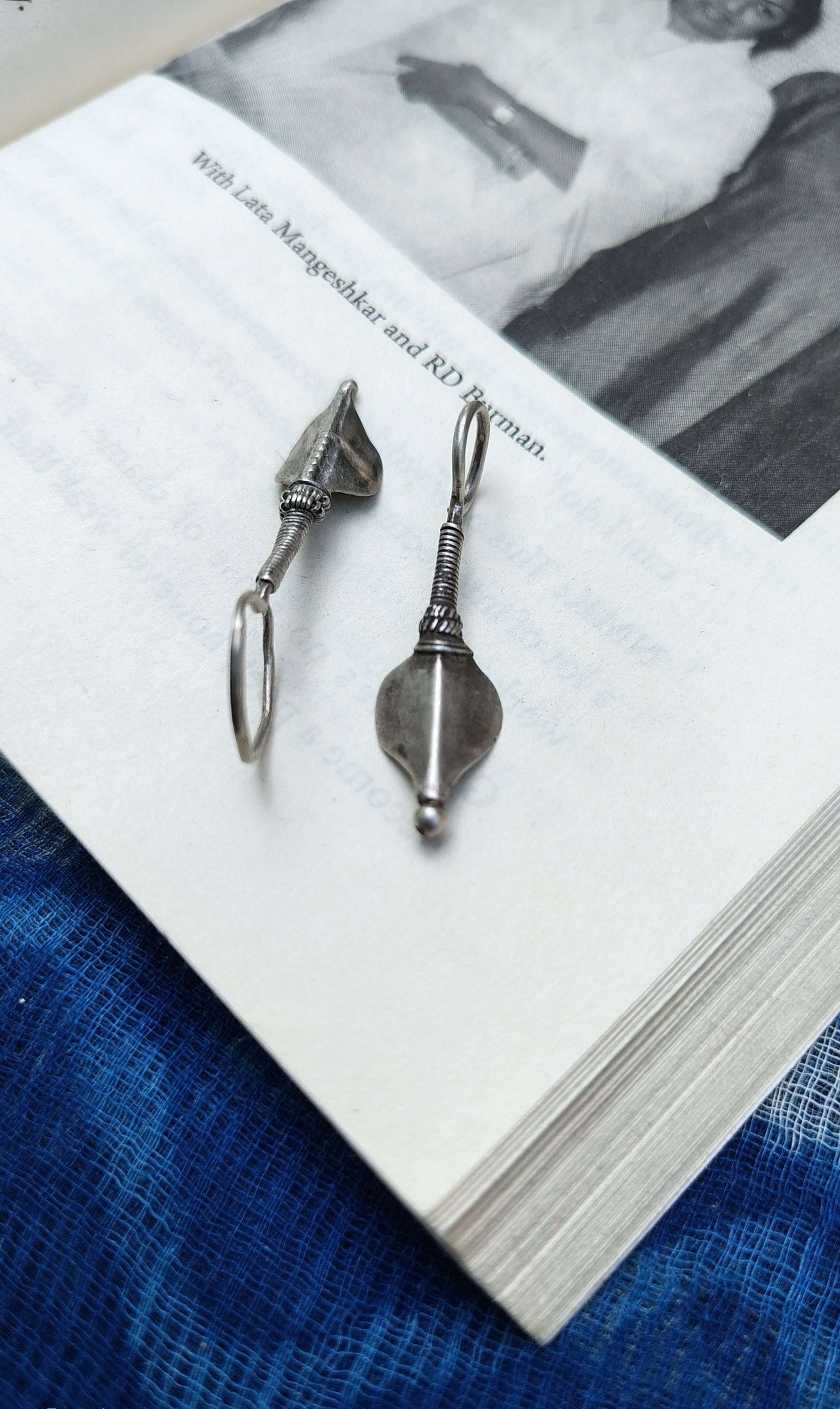 Pair of silver earrings on a book with a blurred background