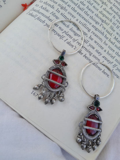 Pair of silver and red earrings on an open book