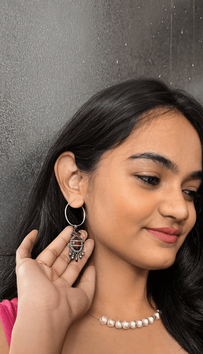 Woman wearing a silver earring with a dark background