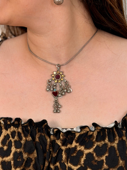 A rare vintage silver maximalist pendant — hand-cut glass sunflower with red centre and yellow petals, maroon glass heart dangler, turquoise accent, dense ghungroos and geometric danglers throughout. Available with or without chain.Worn photo.