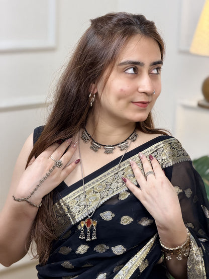 Vintage silver necklace with five taweez pendants on black dori — each with geometric embossing and three sets of three ghungroo clusters. Protective, ornate, heirloom. Shop Sadabahaar Jewelry.