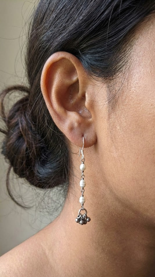 Close-up of an ear wearing a dangling earring with a neutral background Sadabahaar Jewelry