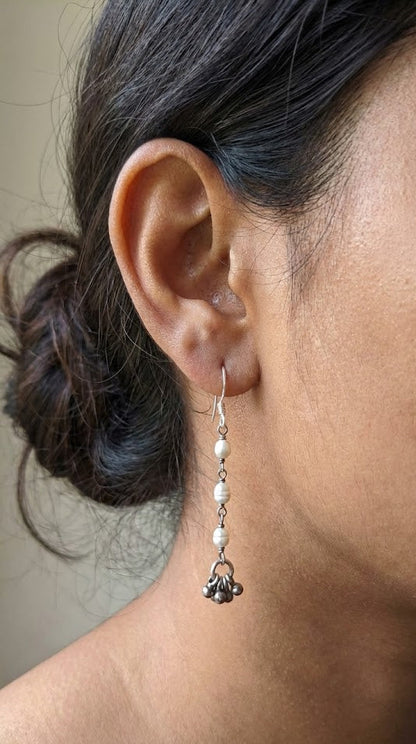 Close-up of an ear wearing a dangling earring with a neutral background Sadabahaar Jewelry