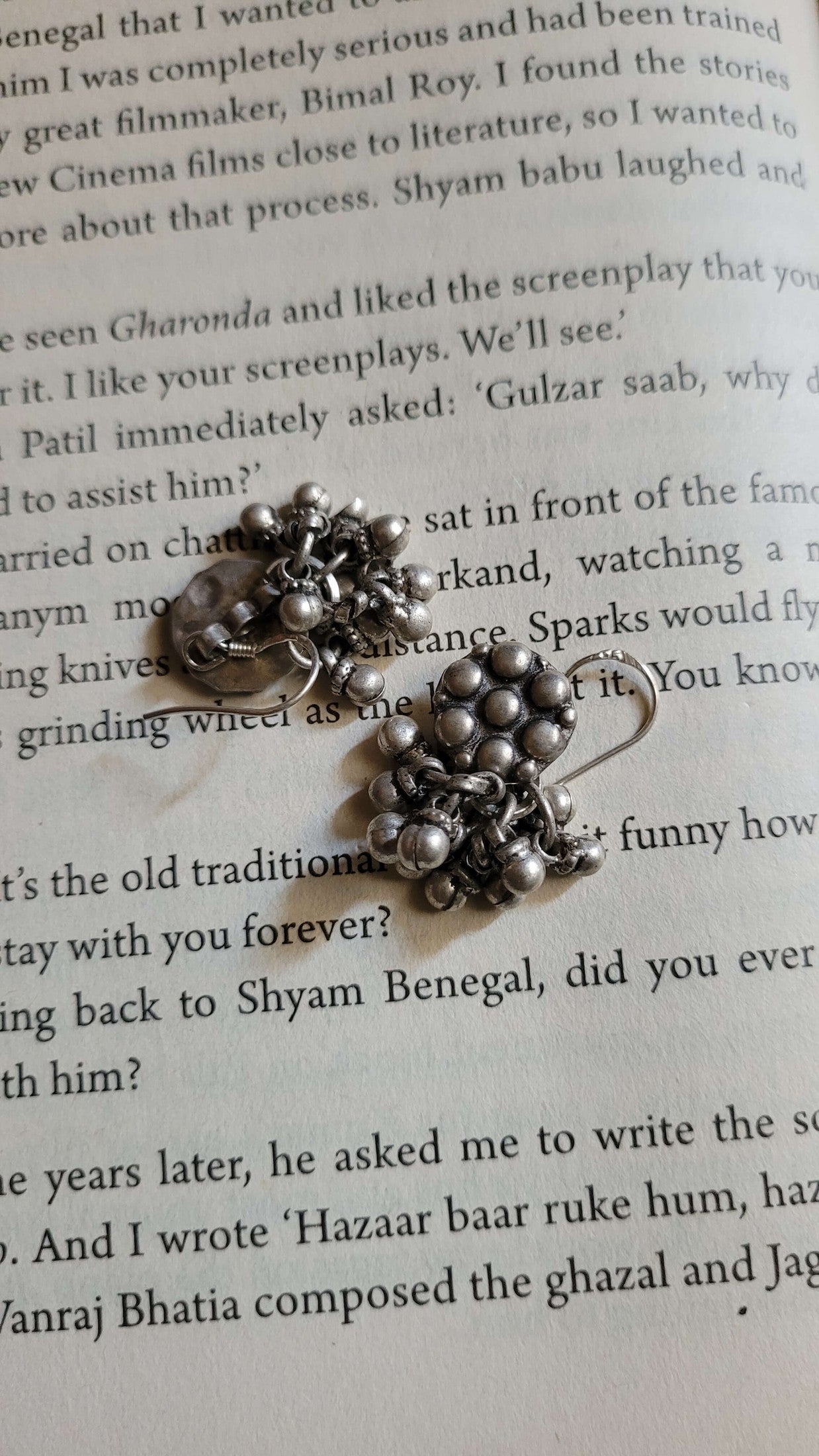 Silver earrings on a book page