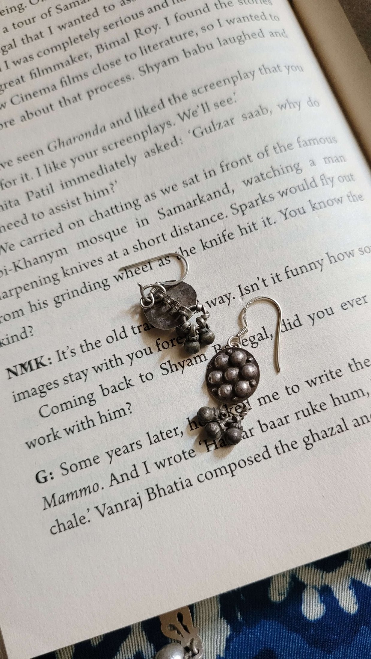 Pair of silver earrings on a book page
