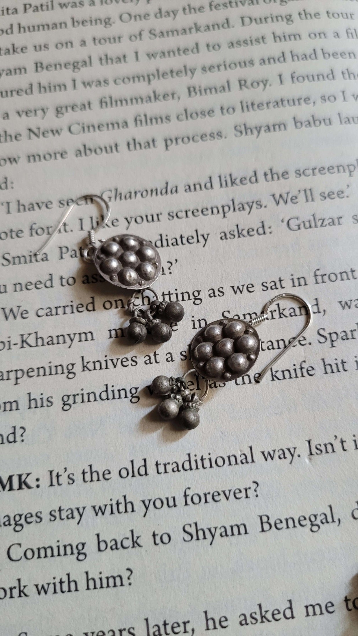 Pair of silver earrings on a piece of text