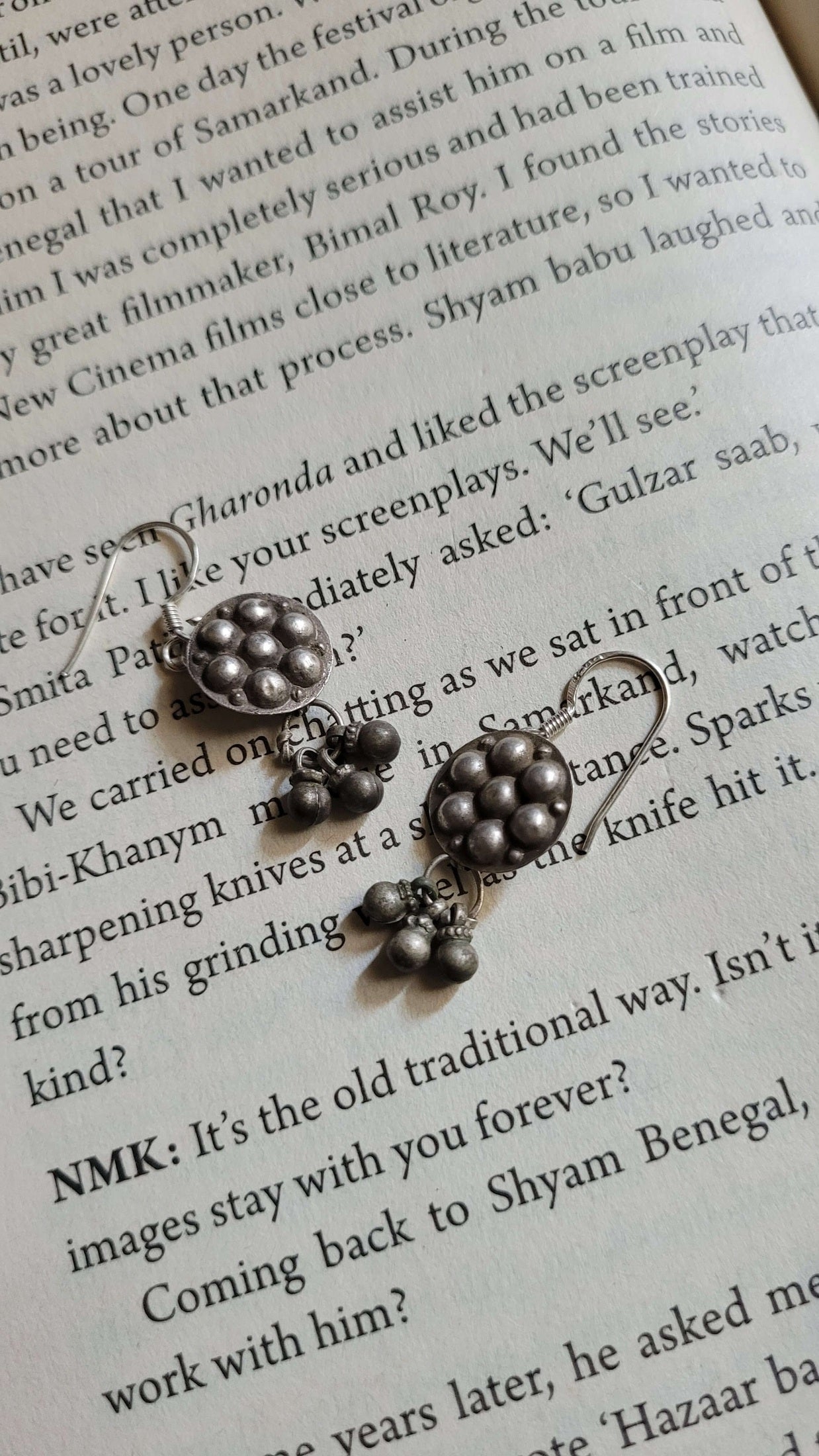 Silver earrings on a book page