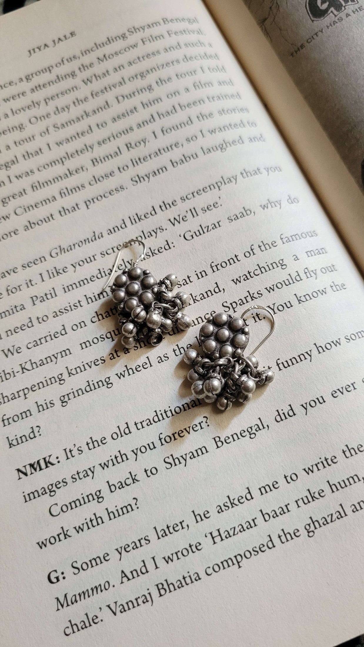 Silver vintage earrings on an open book
