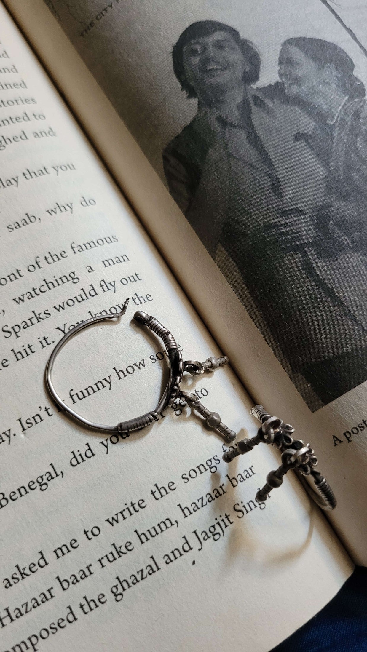 Silver hoops with floral design on an open book