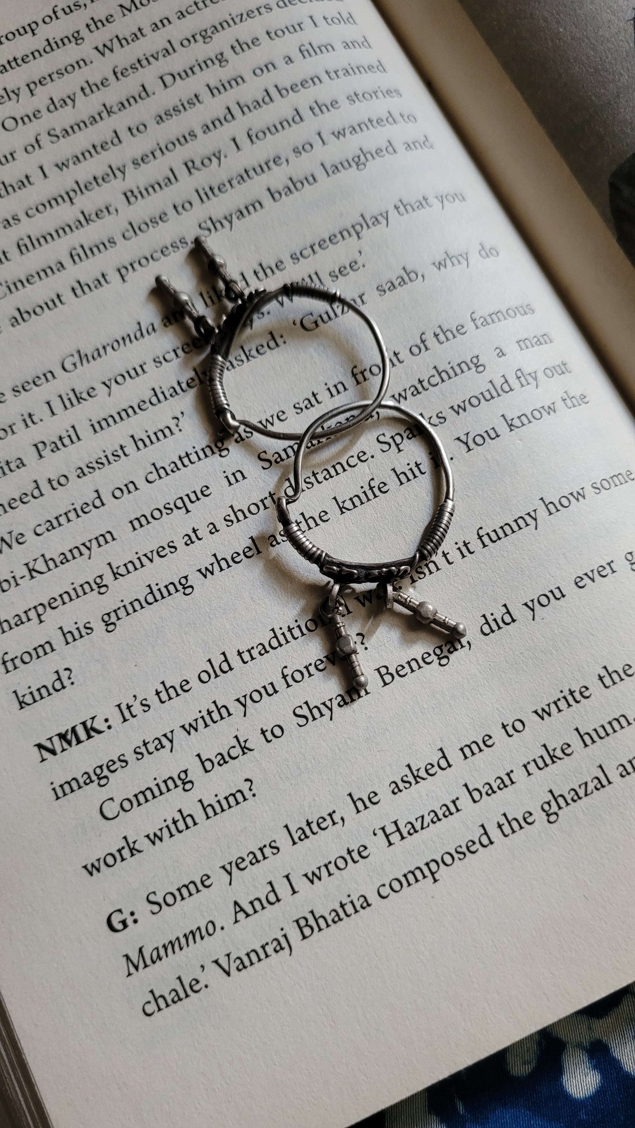 Silver hoops with decorative elements on an open book