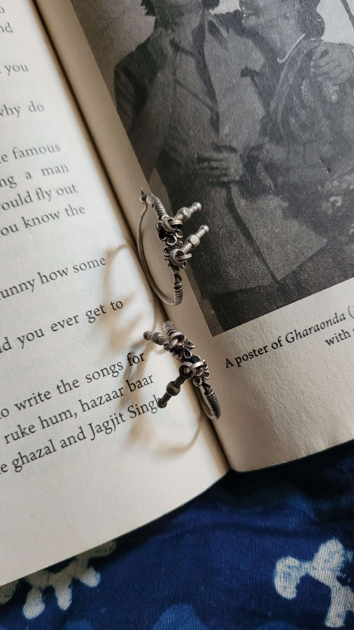 Silver hoops on an open book with a black and white photo in the background