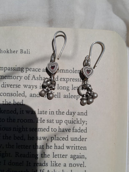 Silver heart-shaped earrings on an open book