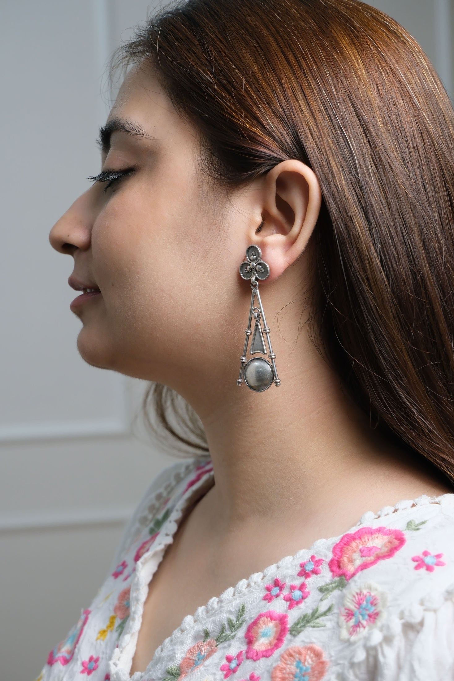 Close-up of a woman wearing Big Ben Earrings with a neutral background