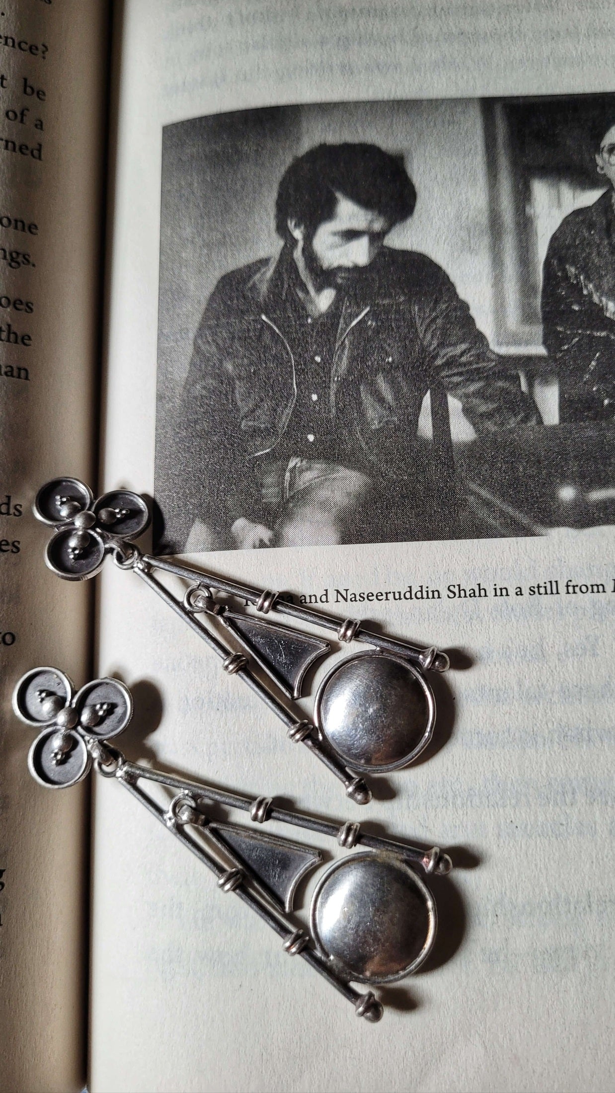  Big Ben silver earrings on an open book with a black and white photo of a man in the background.