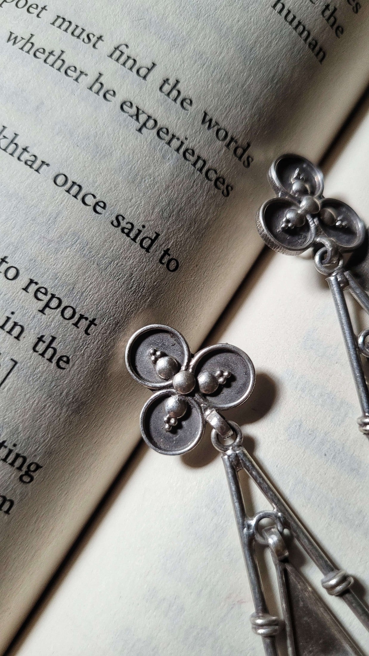Silver earrings on an open book