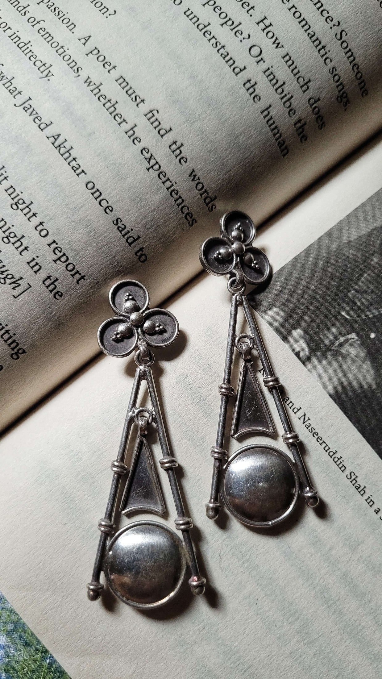 Silver earrings on an open book