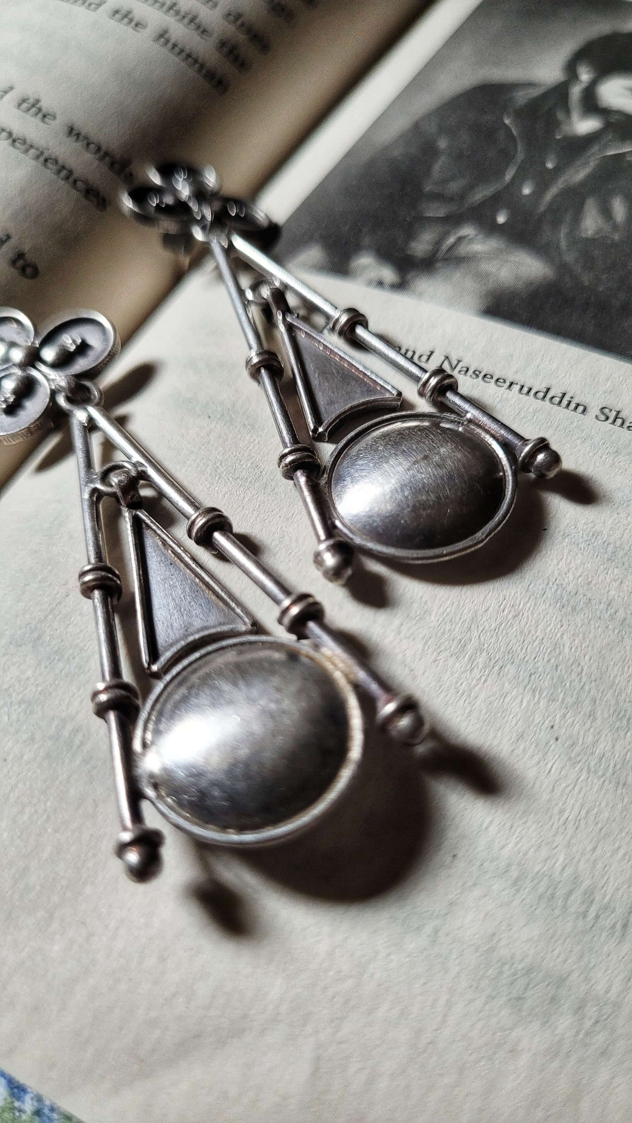 Pair of silver earrings on an open book