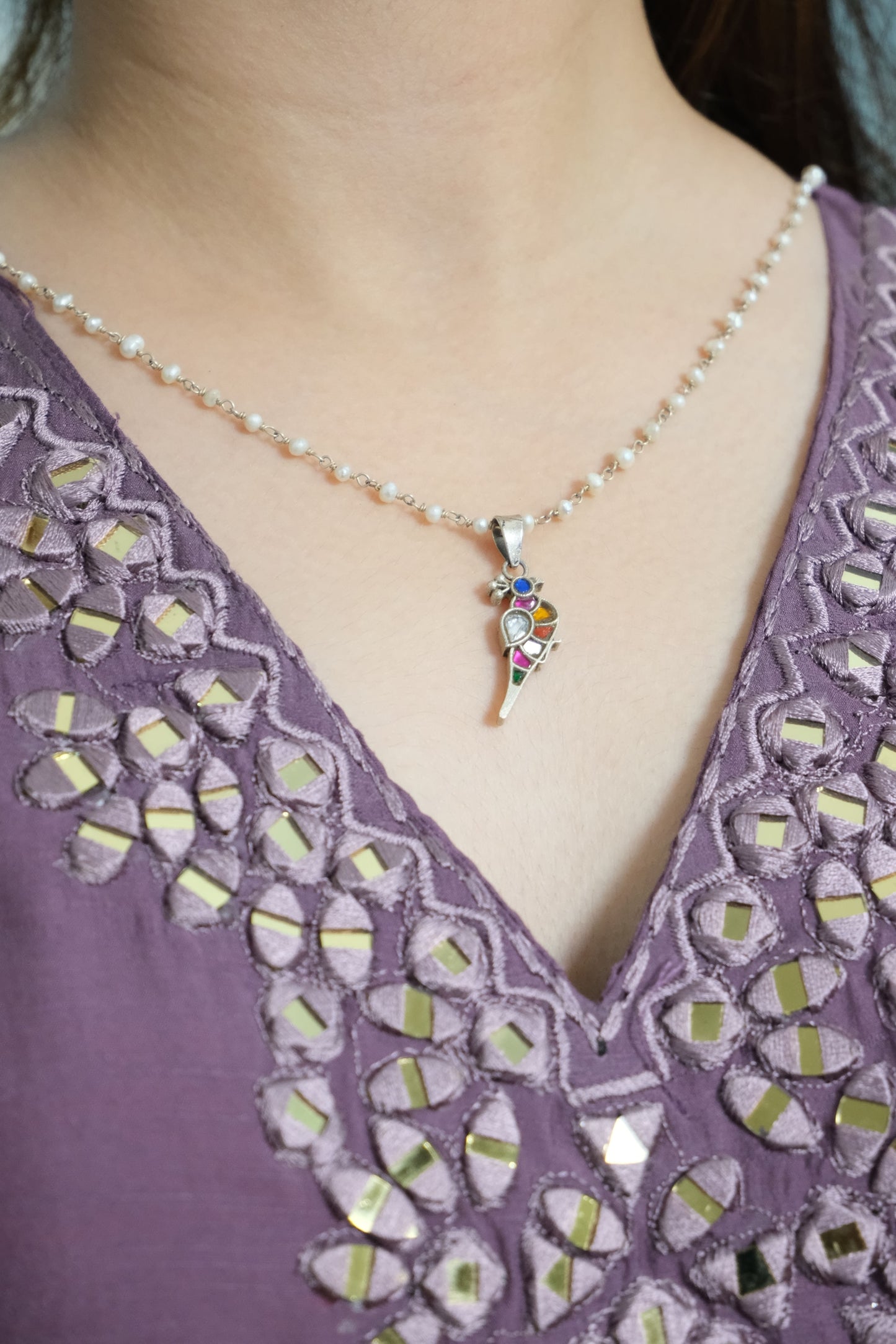 Close-up of a person wearing a colorful Bulbul Pendant.