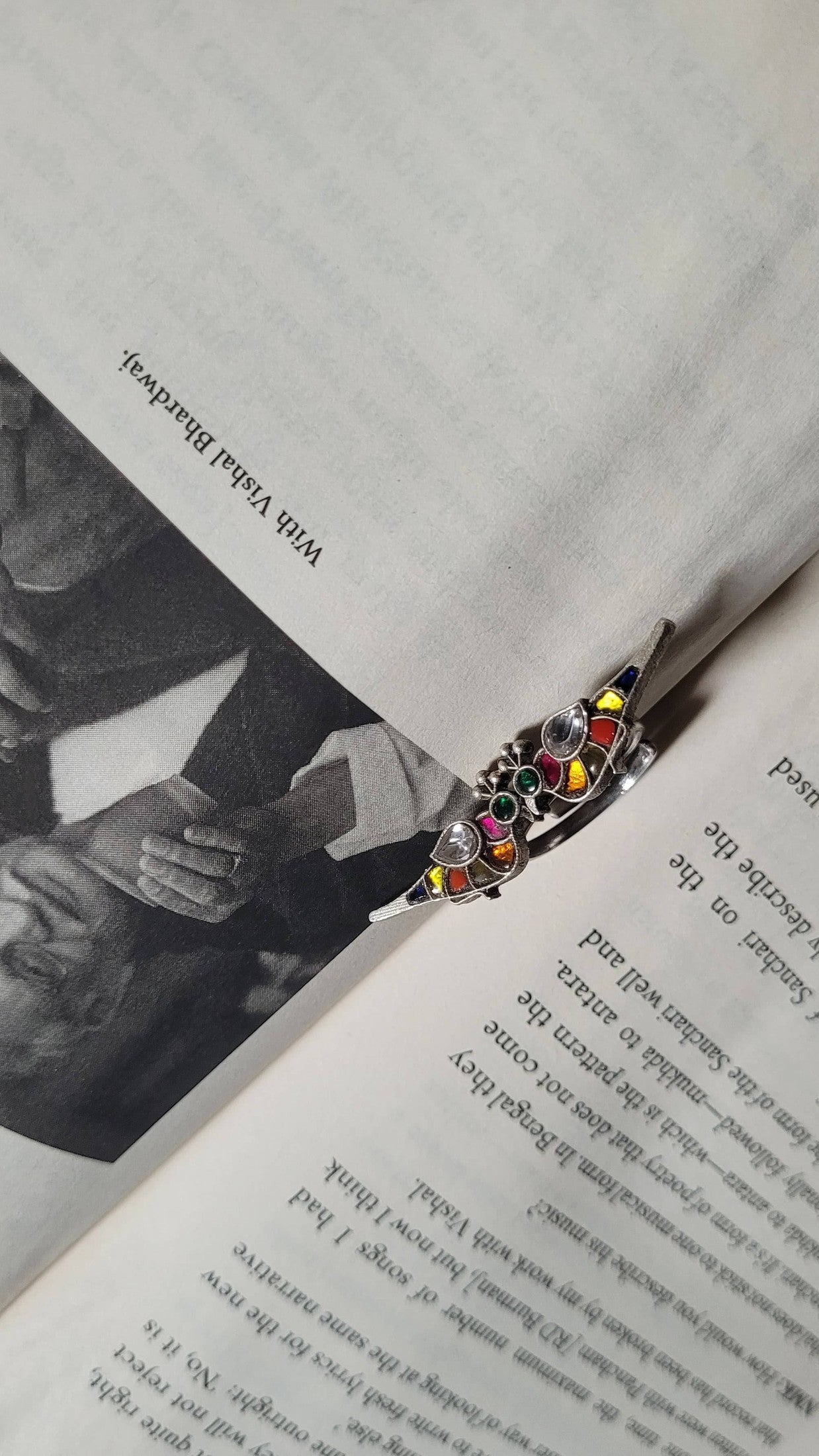 Open book with a colorful bird ring on the page