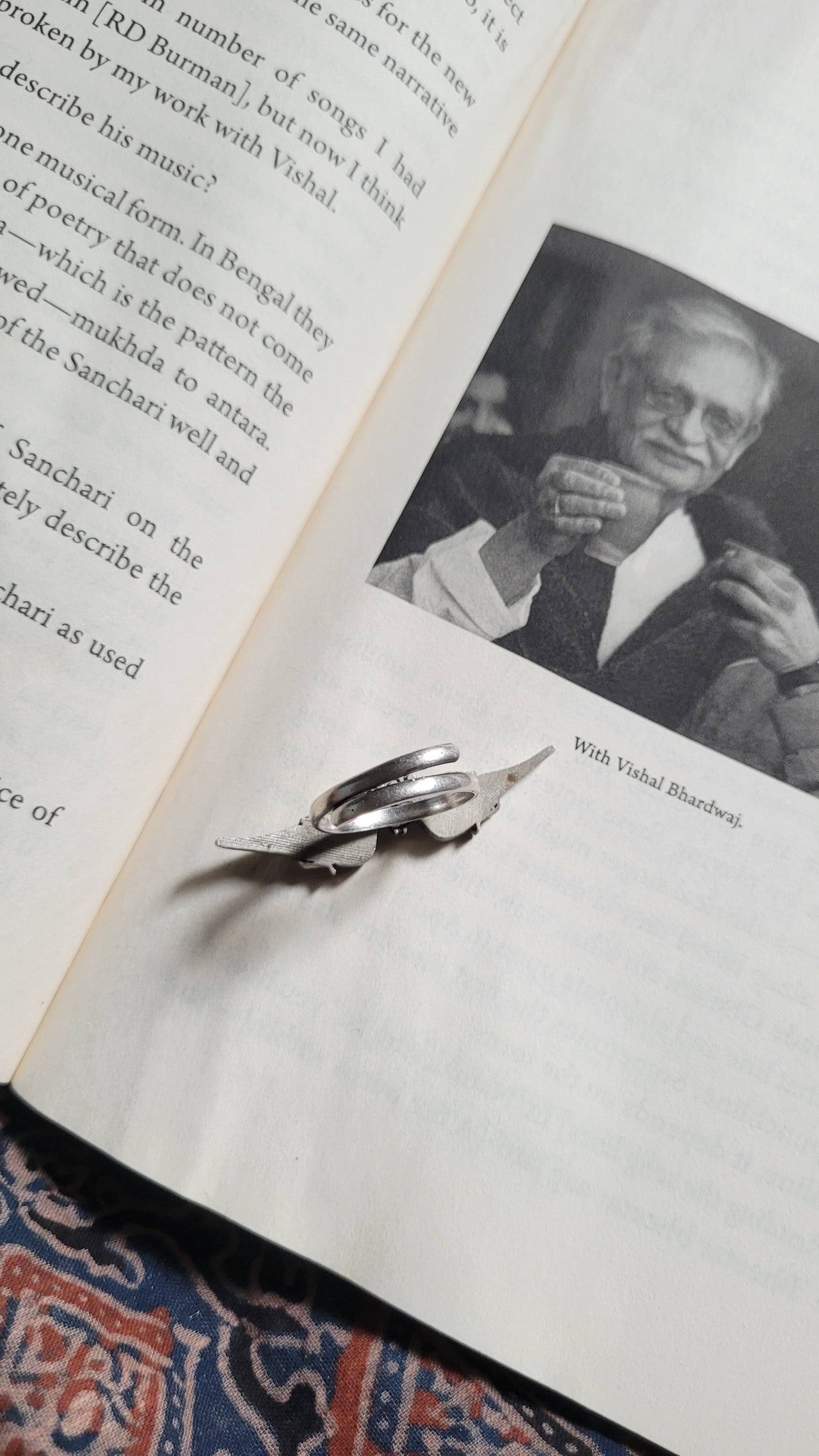 Open book with a black and white photo of a man and Bulbul Ring on top