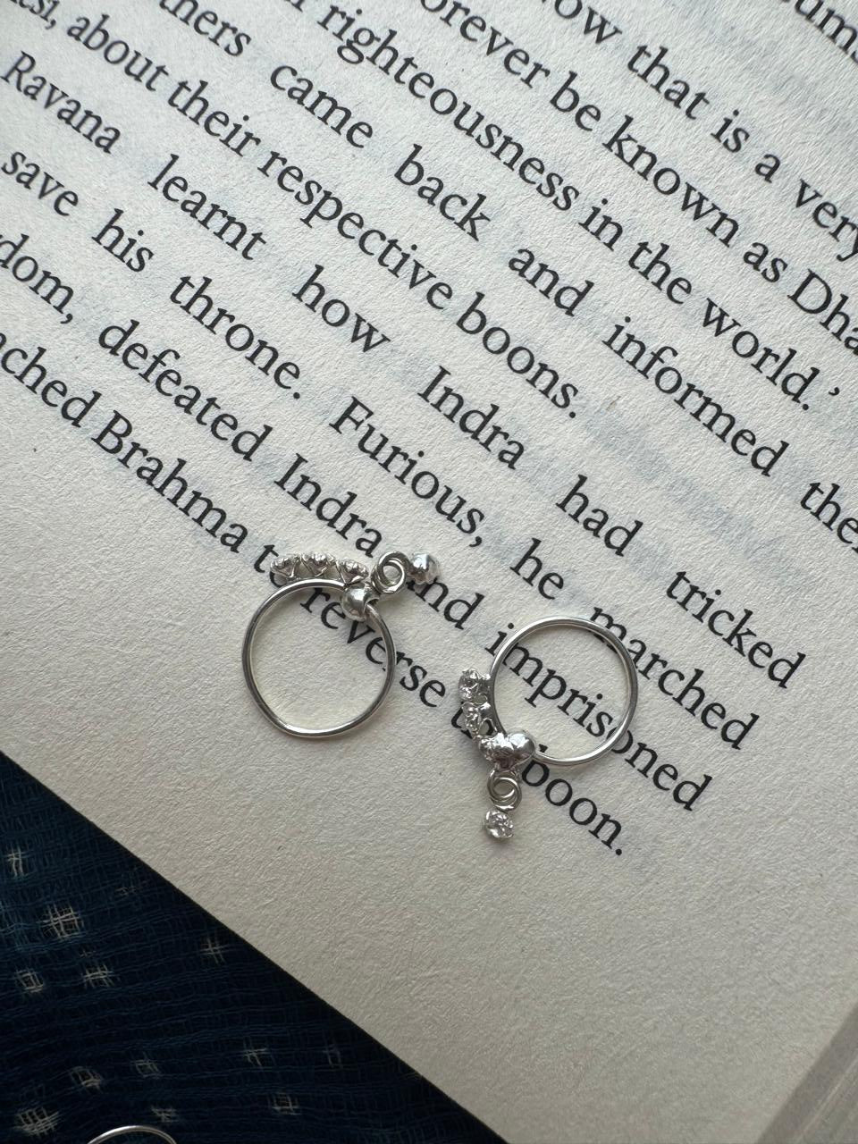 Silver hoops with charms on a book page