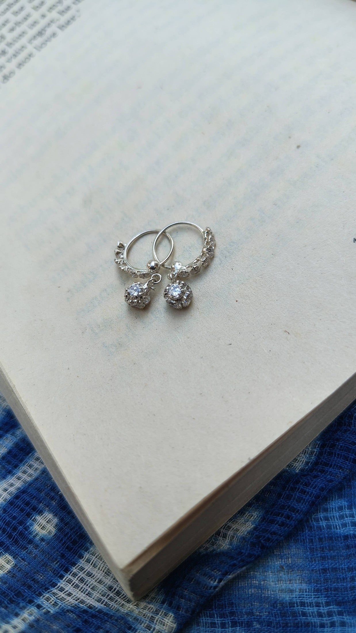 Silver earrings with CZ white stones on a piece of paper| Sadabahaar Jewelry