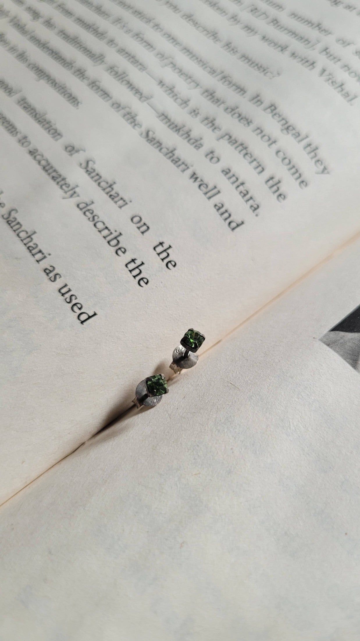 Small green earrings on a book page