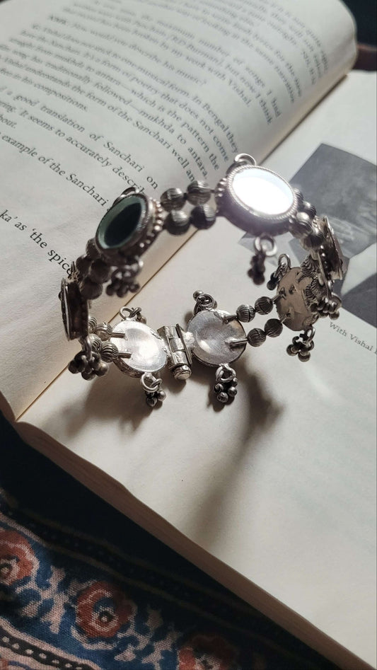 Silver bracelet with black and white stones on an open book