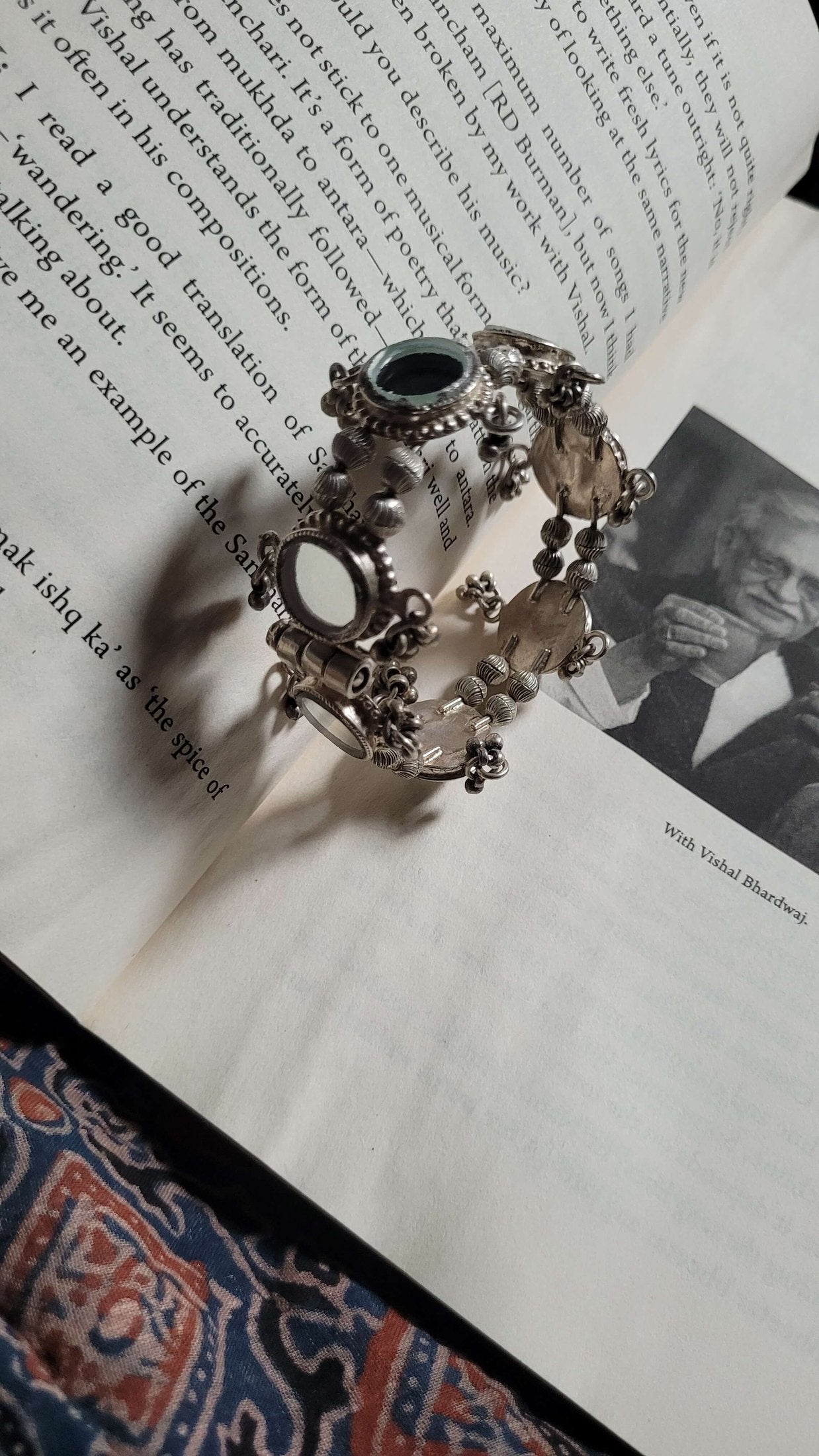 Dhruvnanda Kada on an open book with a black and white photo underneath