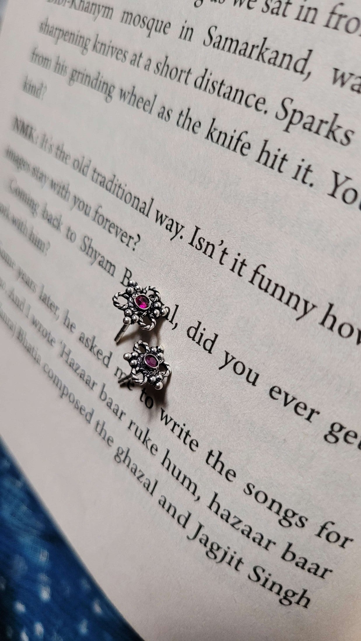 Pair of earrings with Eros Studs on an open book