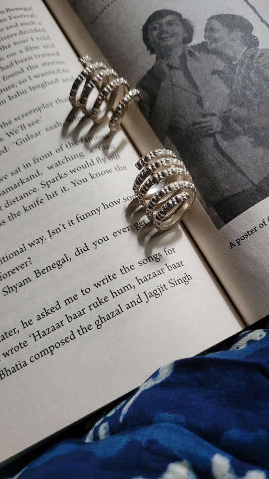 Silver spiral rings on an open book with a photo of two people on the page