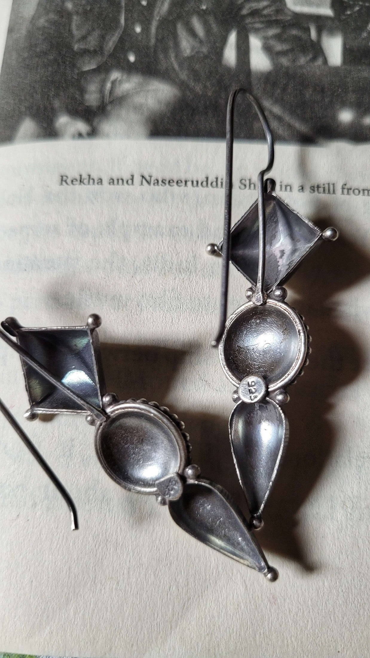 Pair of silver earrings on a book page