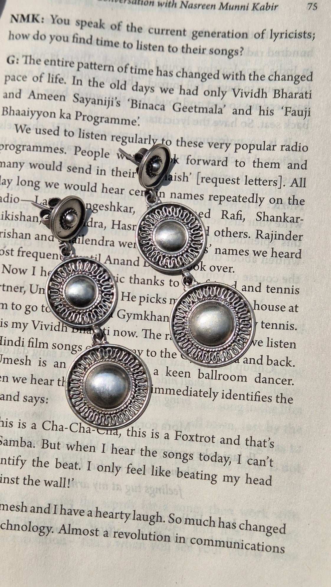 Set of silver circular earrings on an open book