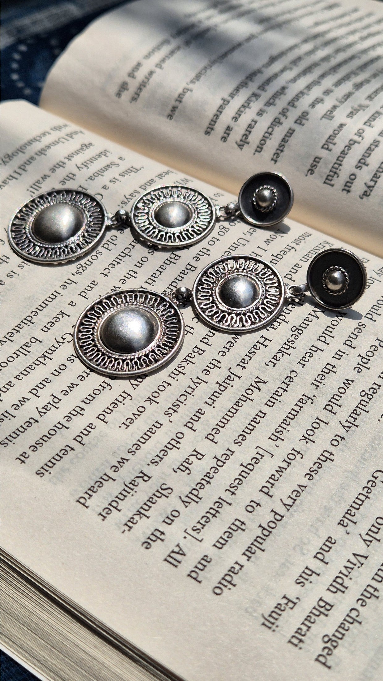 Silver earrings on an open book