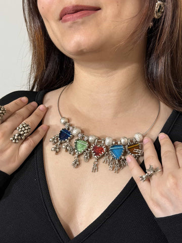 Colorful necklace with glass stones worn by a person, close-up on neck and shoulders.