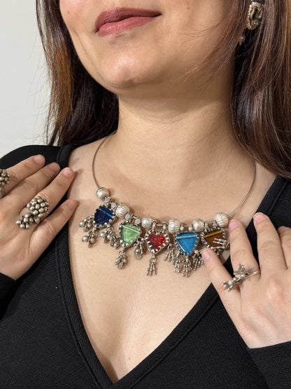 Colorful necklace with glass stones worn by a person, close-up on neck and shoulders.