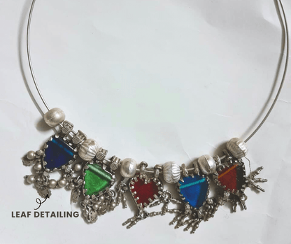 Necklace with colorful heart-shaped pendants and leaf detailing on a white background - top view
