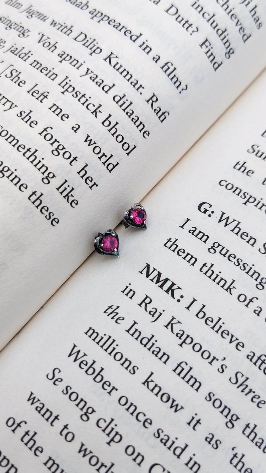 Pair of pink stud earrings on an open book