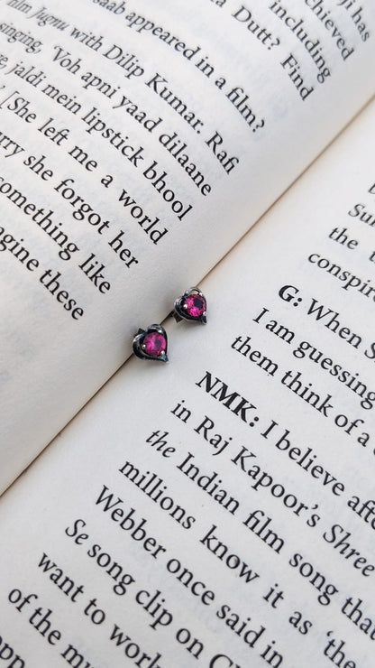 Pair of pink stud earrings on an open book