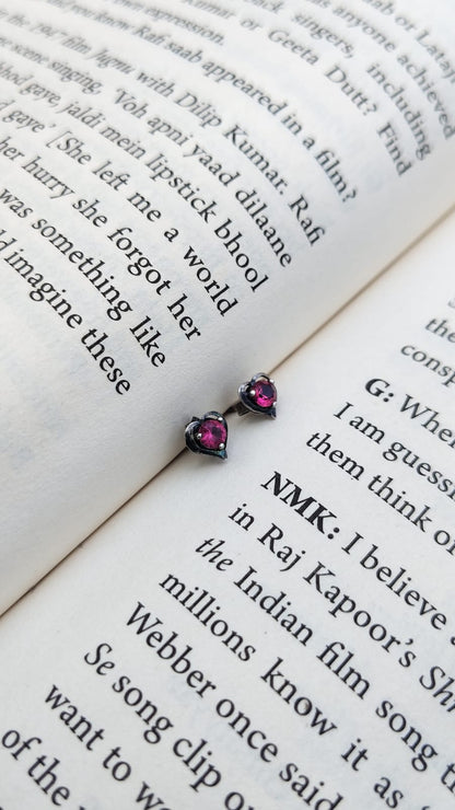 Pair of earrings with pink gemstones on an open book