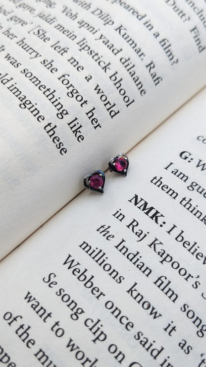 Heart-shaped 92.5 silver pink earrings on an open book with text