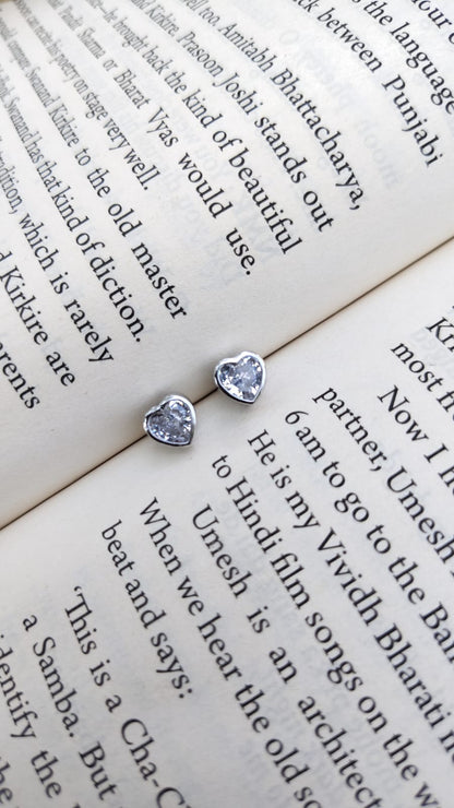 Heart-shaped 92.5 silver white zirconia earrings on an open book