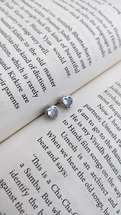 Heart-shaped earrings on an open book