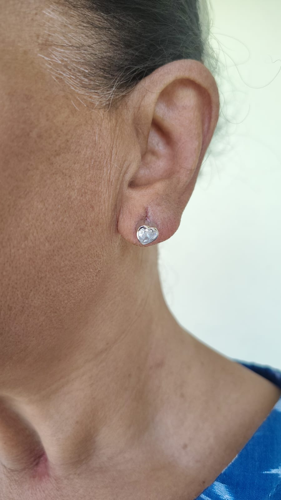 Close-up of an ear wearing 92.5 silver stud earring with a blurred background
