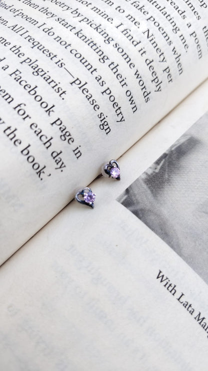 Purple earrings on an open book