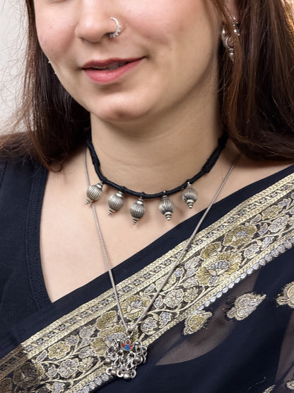 92.5 silver necklace with five 3D kalash-inspired lattoo beads — geometric embossed lines, three raised dots at base — on black dori. Minimalist, sacred-inspired, daily wear. Shop Sadabahaar Jewelry.