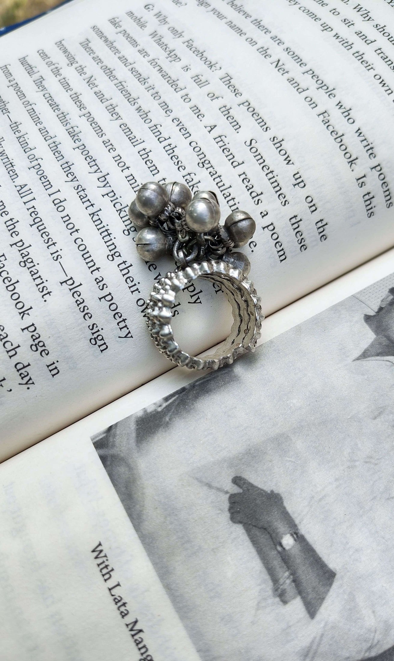 Silver ring with bells on an open book