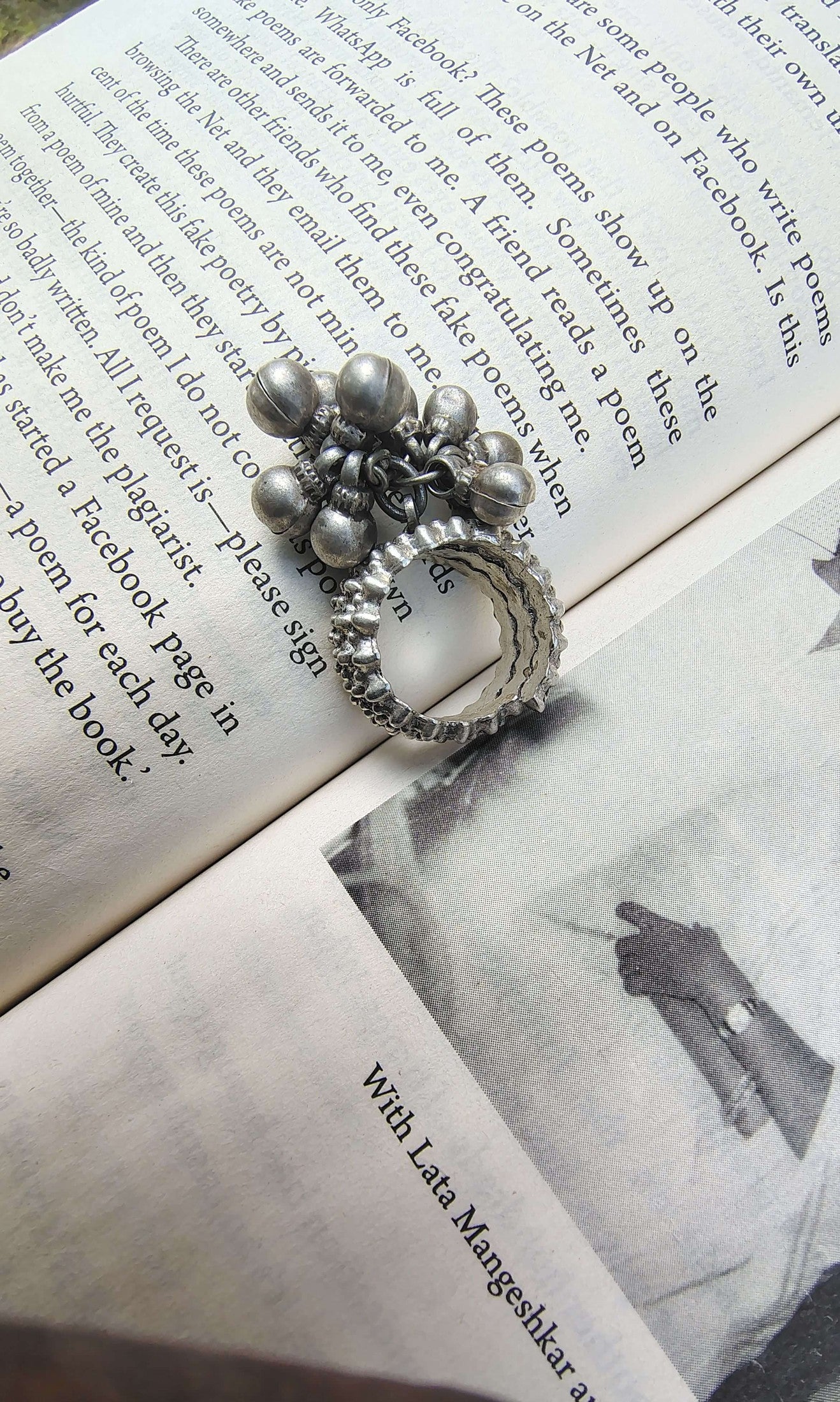 Silver ring with floral design on an open book
