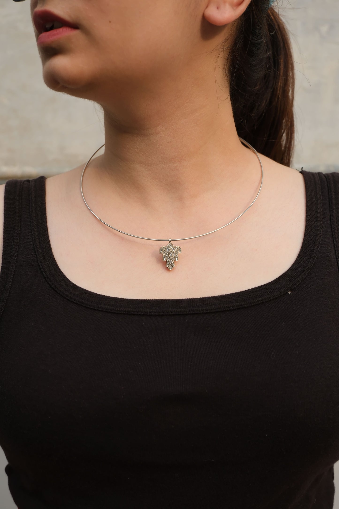 Person wearing a black top with Katla Pendant and hasli around their neck.